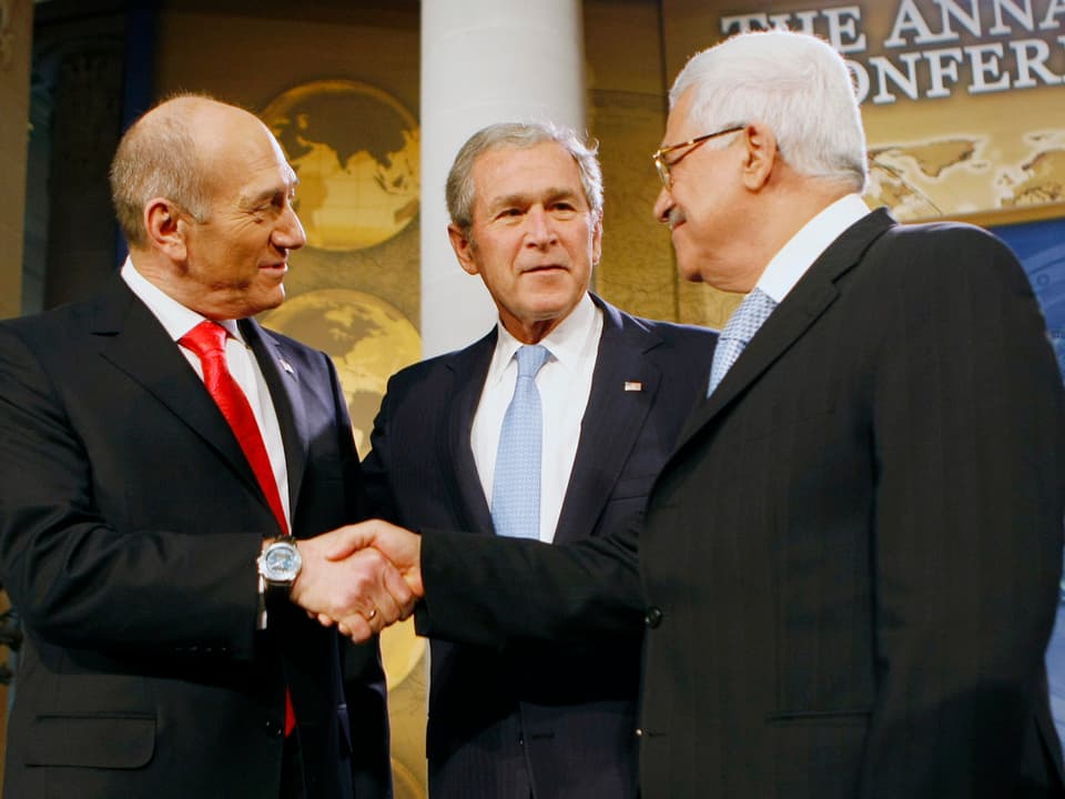 Bush schaut zu, wie sich Olmert und Abbas die Hand reichen.