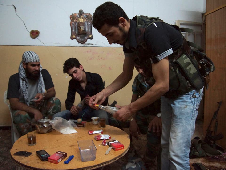 Rebellen bauen in einem abgedunkelten Zimmer in Deir al-Zor Waffen, die sie später auf Streitkräfte des syrischen Präsidenten Bashar al-Assad abfeuern.