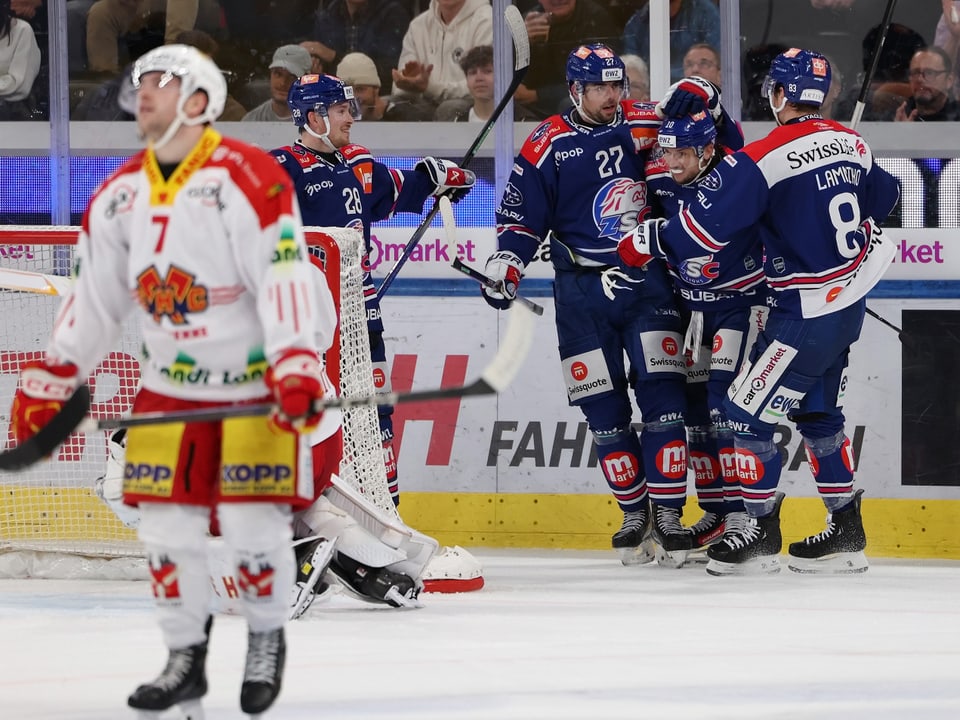 Eishockeyspieler feiern auf der Eisfläche.