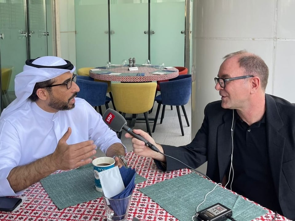 Auslandredaktor Philipp Scholkmann interviewt in Dubai einen Publizisten am Tisch. 