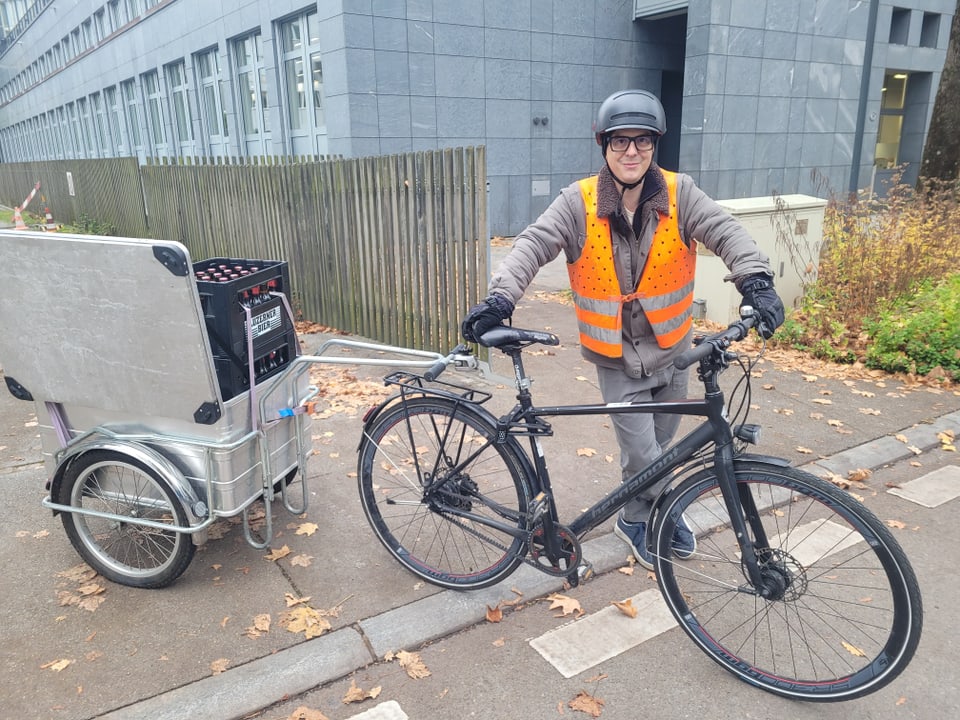 Mann mit Velo und Anhänger