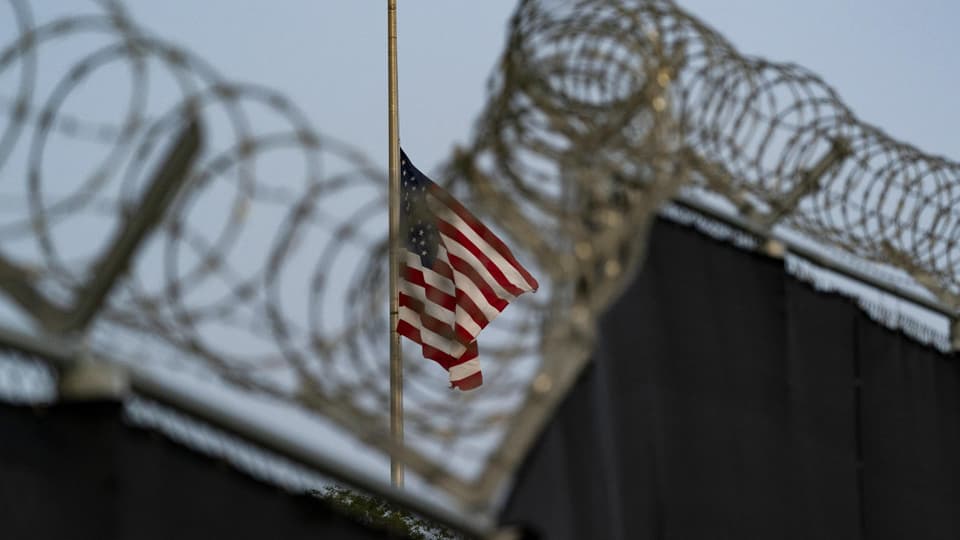 Blick auf US-Flagge durch Stacheldraht hindurch