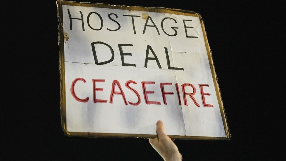 Demonstrant in Tel Aviv mit Schild, auf dem «Geisel-Deal – Waffenruhe» steht