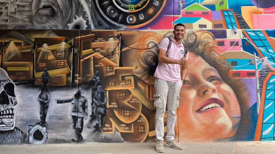 Sebastián Soler steht vor einem Graffiti, das den Wandel der «Comuna 13» aufzeigt.