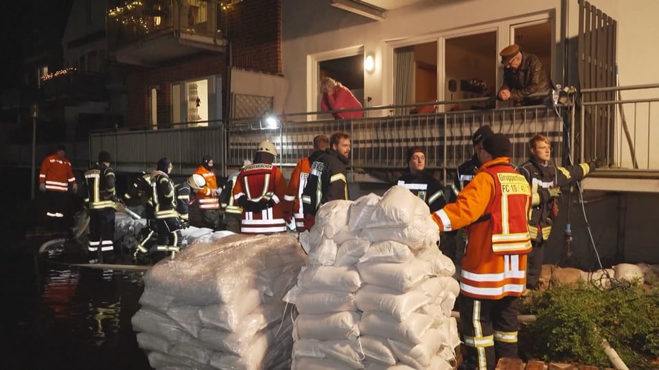 Feuerwehrleute mit Sandsäcken