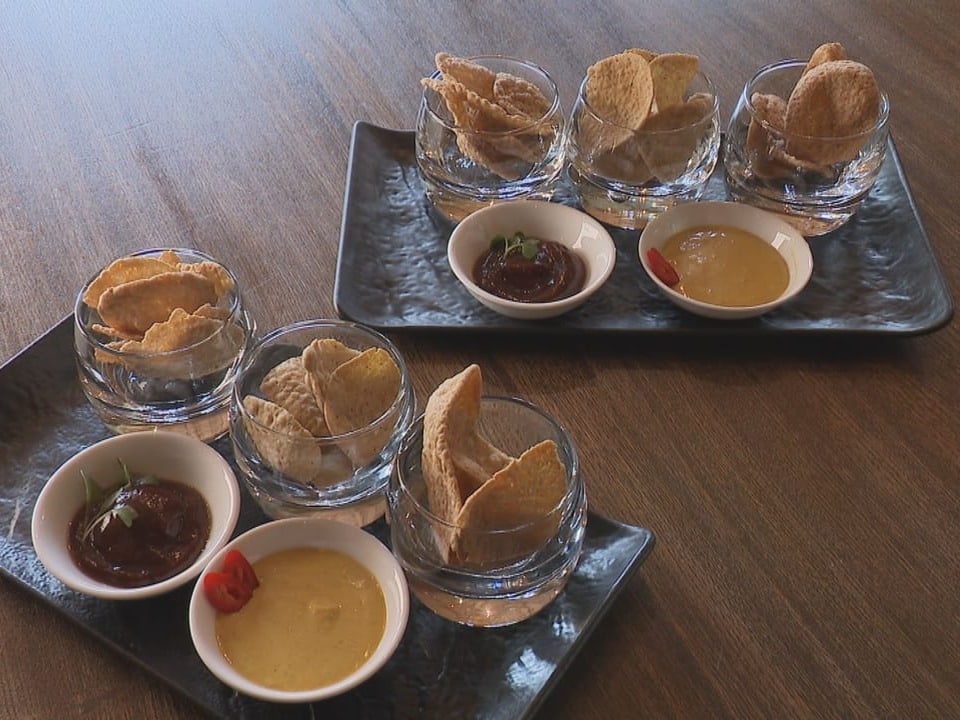 Chips and dip in glass bowls on serving platters.