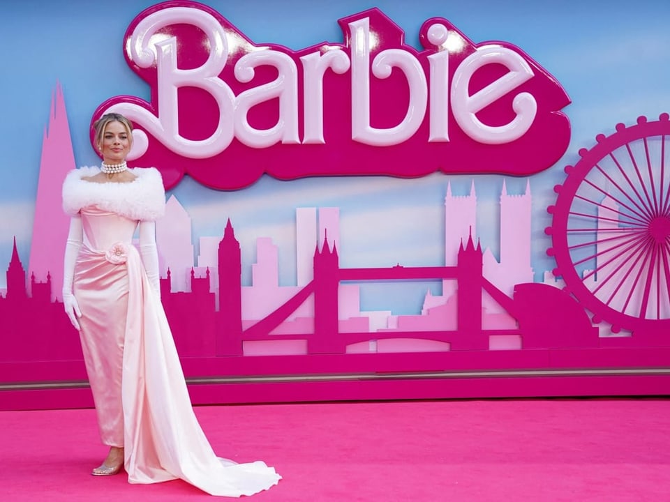 Schauspielerin Margot Robbie vor einem Barbie-Plakat.