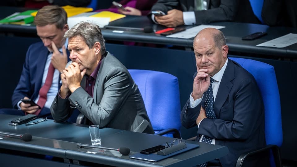 Menschen im Sitzungsraum mit nachdenklichem Ausdruck.