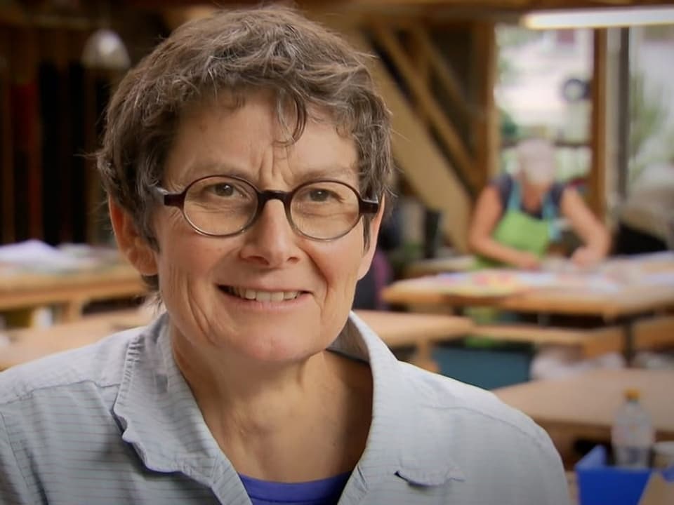 Eine Frau mit kurzen Haaren und einer schwarzen Brille.