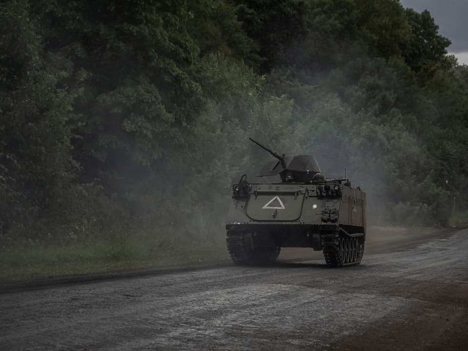 Gepanzerter Panzerwagen auf einer ländlichen Strasse.