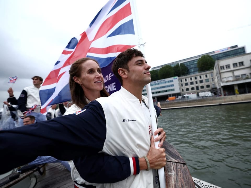Die britischen Fahnenträger Thomas Daley und Helen Glover gestikulieren auf einem Boot, während der Eröffnungsfeier.