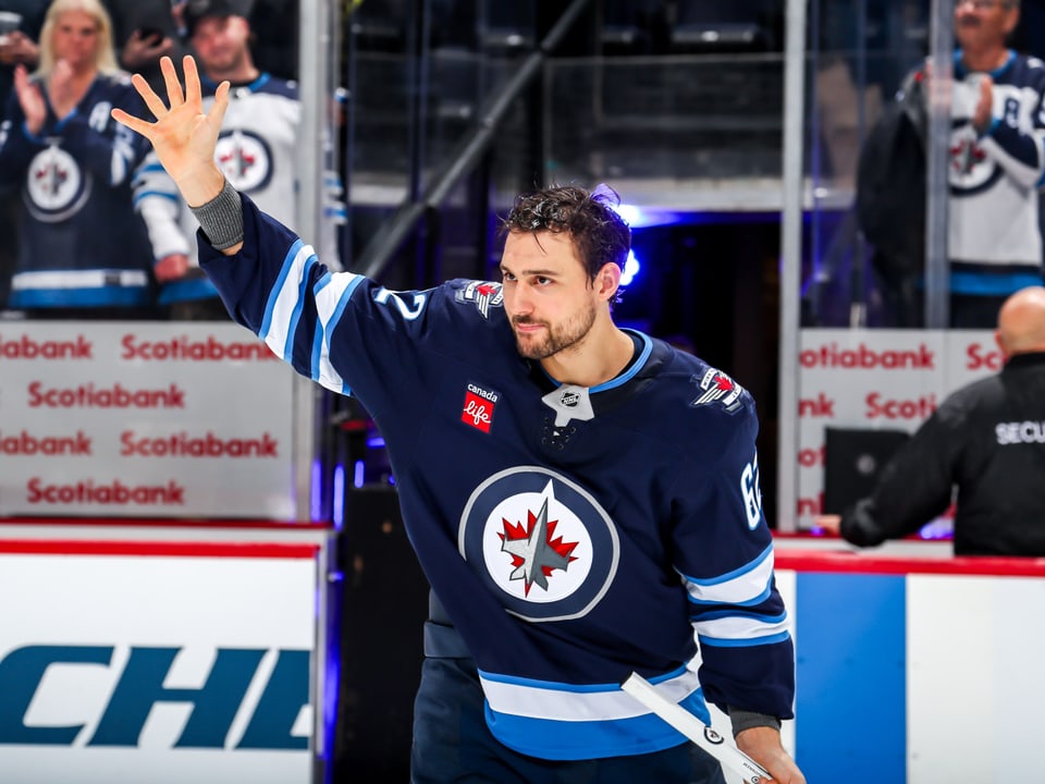 Eishockeyspieler im Trikot der Winnipeg Jets grüsst die Zuschauer.