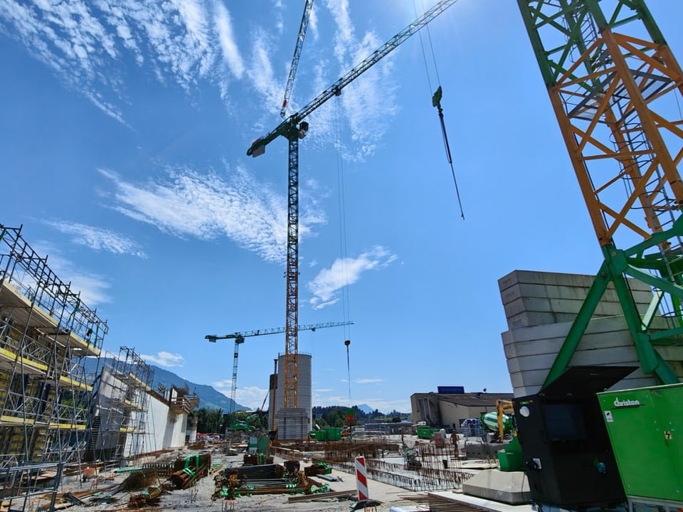 Das Bild der Baustelle, links eine etwa 20 Meter hohe Betonwand, vorne rechts und hinten je ein grosser Kran.