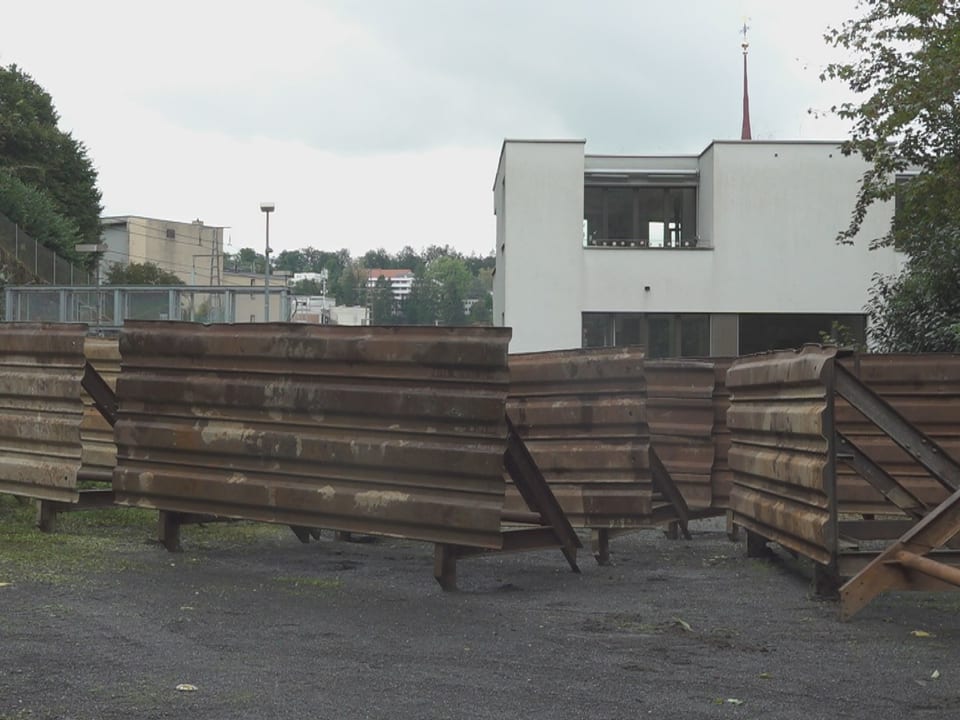 Stahlpalisaden vor Wohnhäusern.