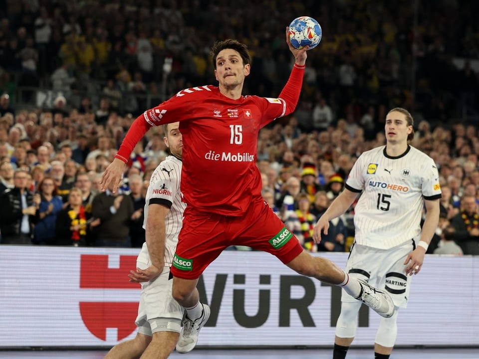 Handballspieler im roten Trikot beim Wurf.