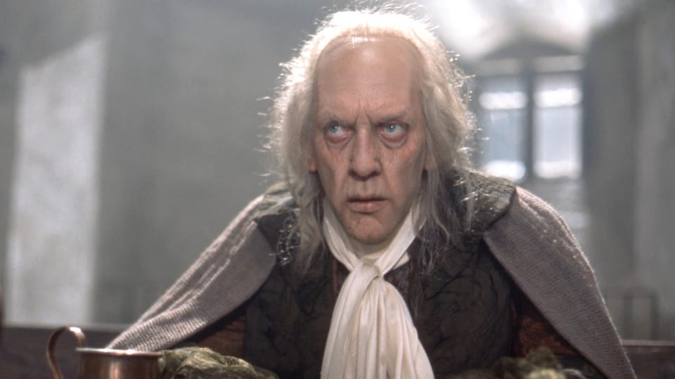 Donald Sutherland mit tiefen Augenrinden, langen weissen Haaren und verkleidet in einem mittelalterlichen Outfit