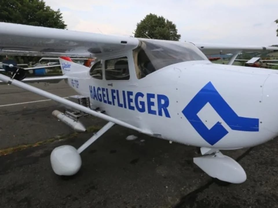 Ein weisess kleines Flugzeug mit blauer Aufschrift «Hagelflieger». 