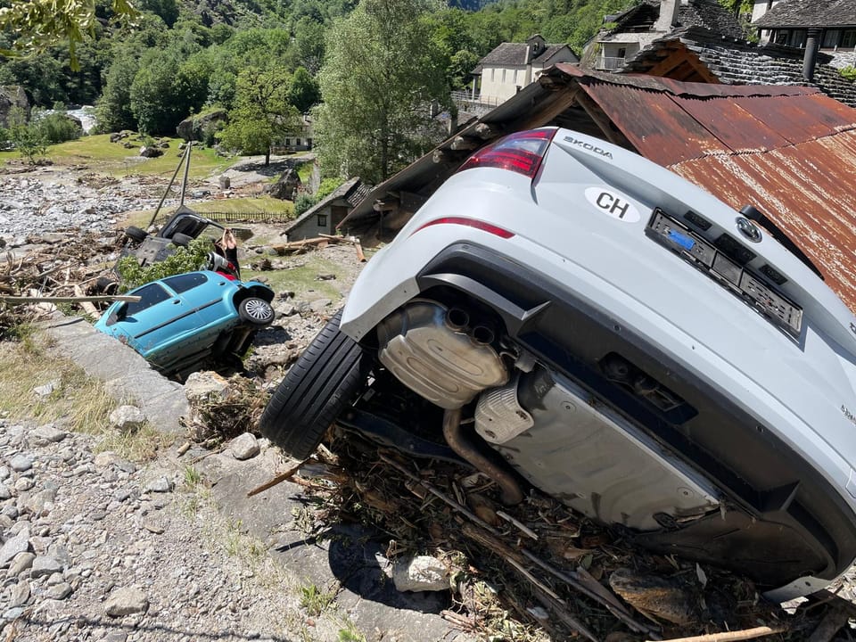Autos von Erdrutsch in steilem Gelände verschoben.