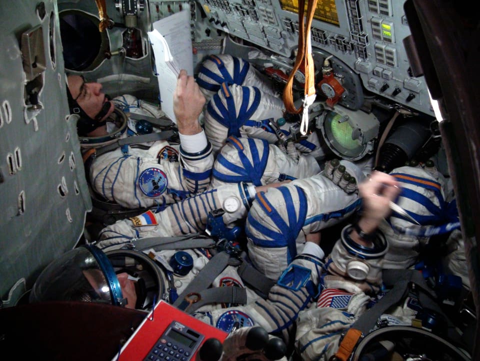 Die Astronauten sitzen im Cockpit. 