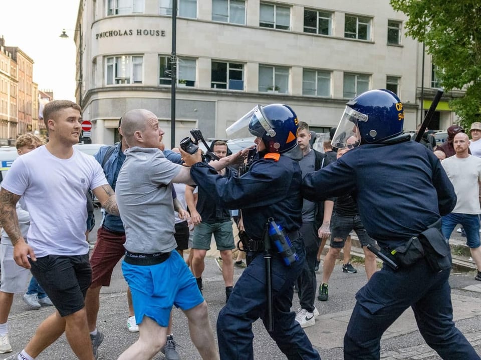 Ein Polizist und ein Demonstrant halten sich unzimperlich.