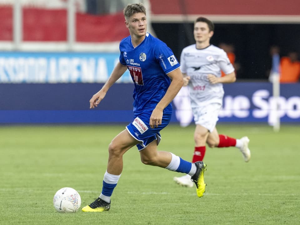 Fussballspieler im blauen Trikot auf dem Spielfeld.