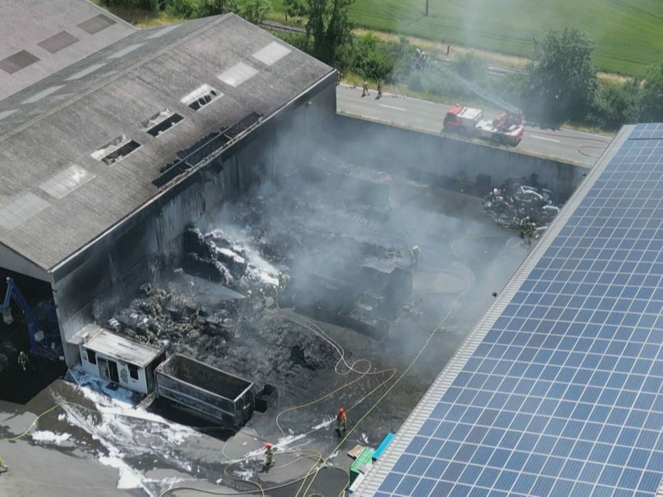 Zwischen zwei grösstenteils verschonten Gebäude die Überreste der verbrannten Halle.