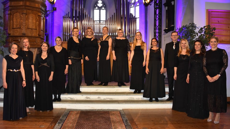 Damenchor Chursüd steht in ganz eleganter und schwarzer Kleidung in einer Kirche.