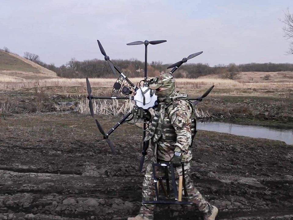 Ein russischer Soldat trägt eine erbeutete ukrainische Drohne.