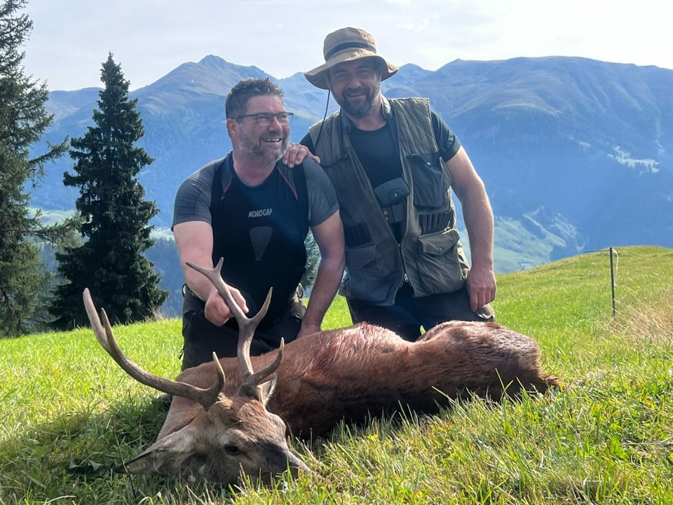 Zwei Jäger mit erlegtem Hirsch