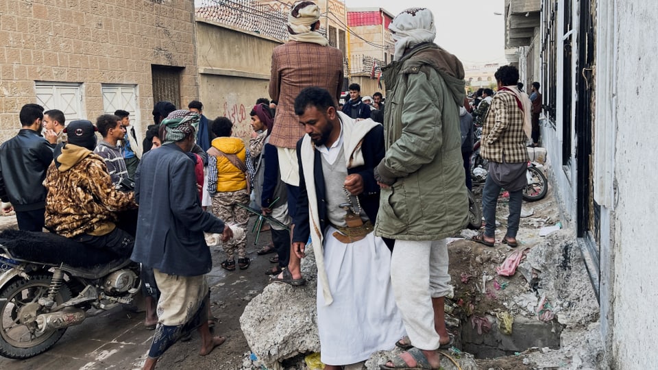 Menschen und Fahrzeuge in einer Strasse in Sanaa.