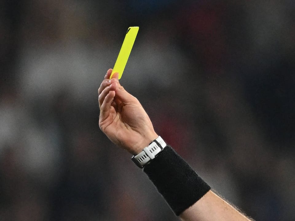 Ein Schiedsrichter zeigt eine gelbe Karte.