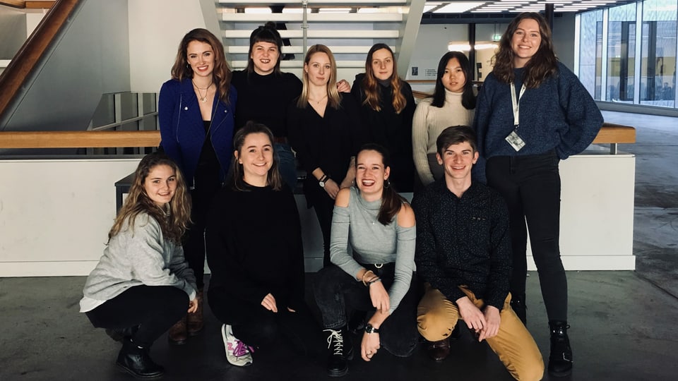 10 Studierende der Zürcher Hochschule der Künste auf einem Gruppenfoto im Gang. 