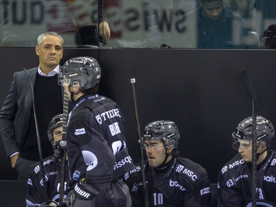 Eishockey-Spieler und Trainer an der Bank.