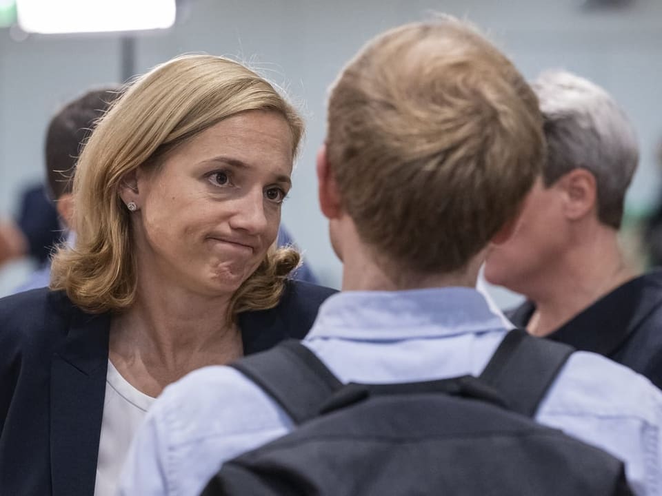 Esther Keller schaut besorgt, während sie mit einer Person redet, die man nur von hinten sieht.