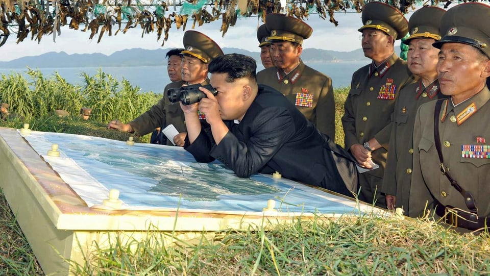 Kim Jong-un verfolgt eine Militärübung mit dem Fernglas.