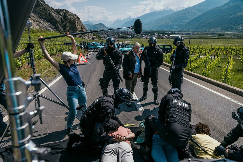 Dreh einer Szene, in der den auf der Strasse liegenden Tschuggern von der Polizei Handschellen angelegt werden.