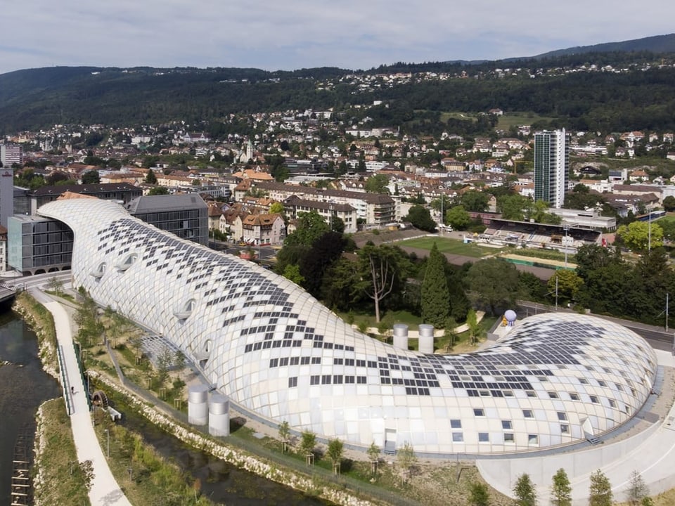 Modernes reptilienförmiges Gebäude an Flüsschen