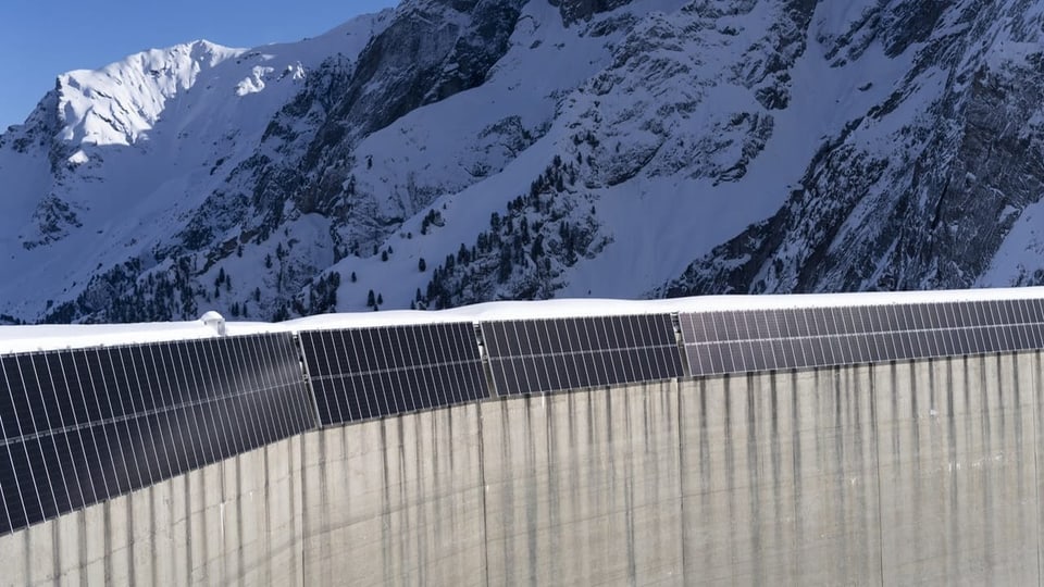 Solaranlagen in den Alpen an einer Staumauer. 