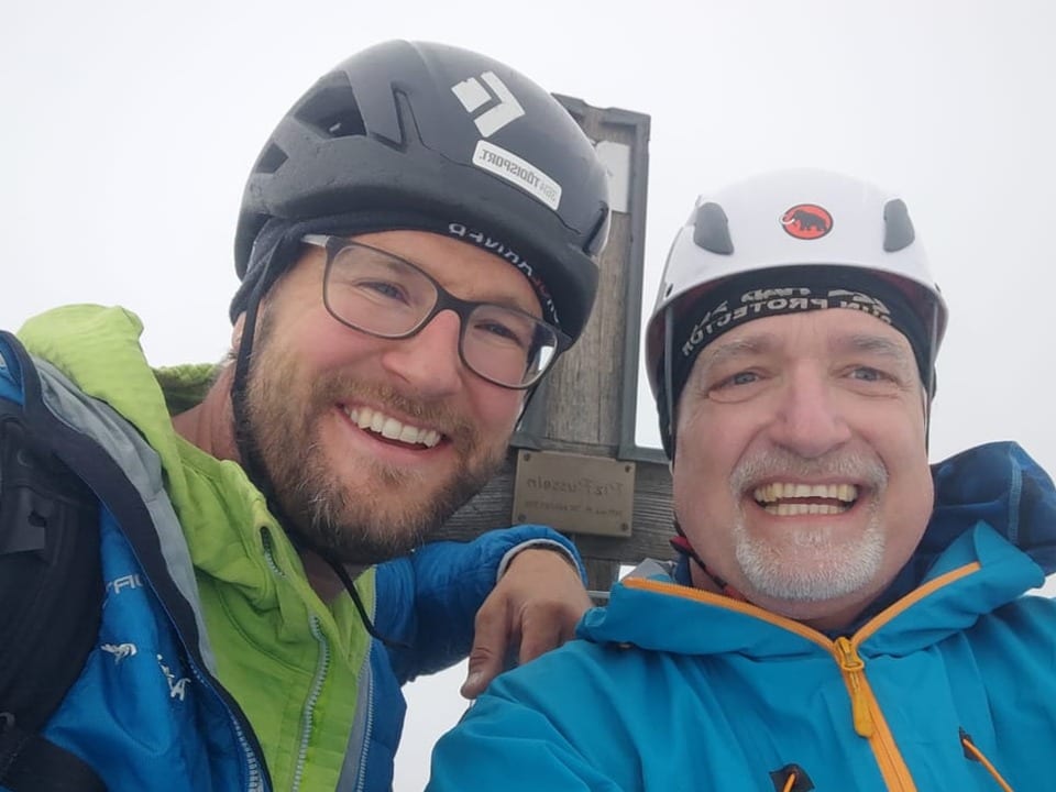 Zwei Männer, Alpinisten vor dem Gipfelkreuz, Piz Russein.