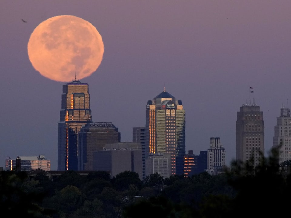 Vollmond über Stadtzentrum mit Wolkenkratzern.