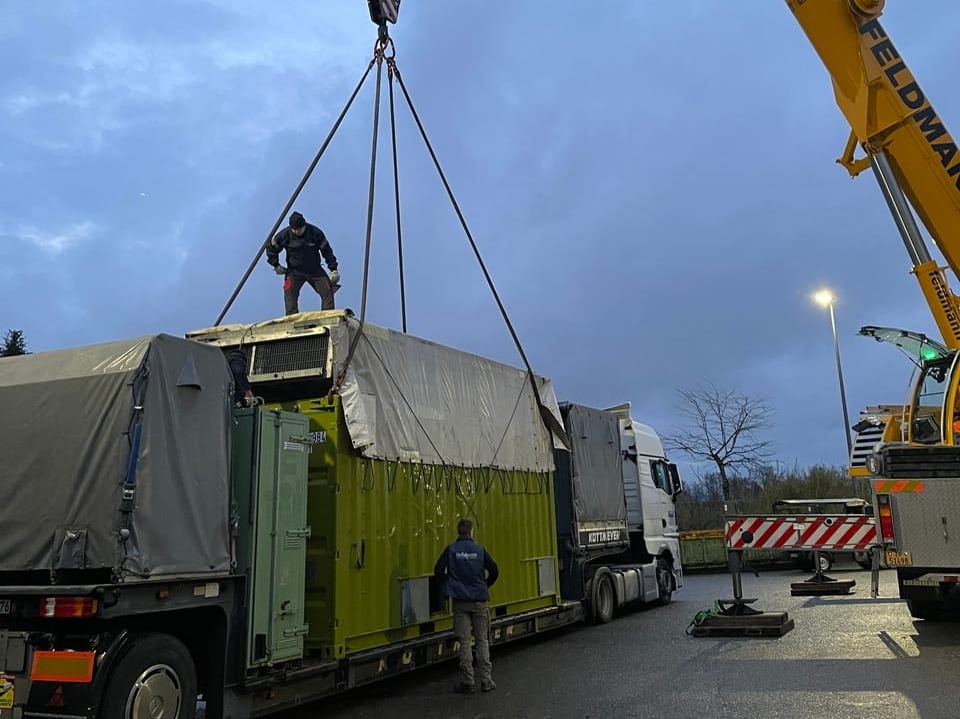 Der Container, in dem sich Panang befindet, wird mit einem Kran vom Lastwagen gehoben. 