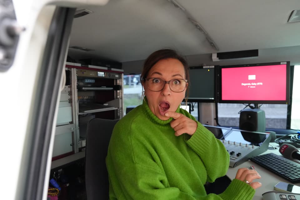 Frau überrascht in einem Fahrzeug mit technischen Geräten.