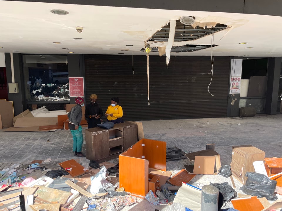 Auf dem Bild ist ein demoliertes Einkaufsgeschäft zu sehen.