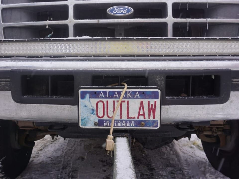 Frontansicht eines alten Ford-Pickup mit einem Nummernschild aus Alaska, das 'OUTLAW' zeigt.