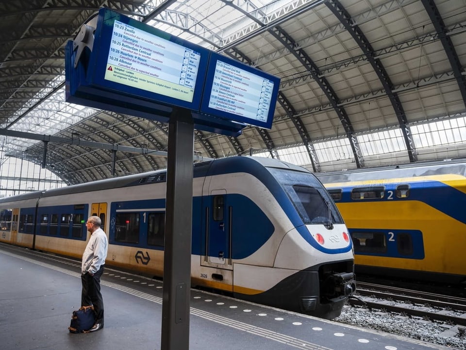 Mann wartet auf Zug in Amsterdam. 