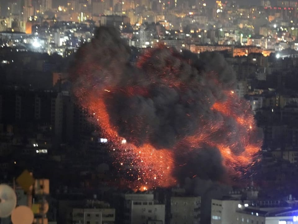 Explosion über einer Stadt bei Nacht.