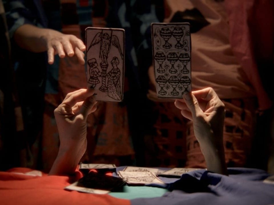 Person hält zwei Tarotkarten in den Händen.