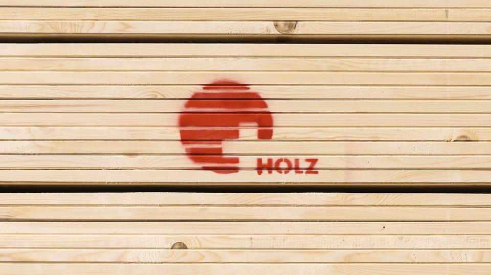 Stapel mit Holz und einem Logo.