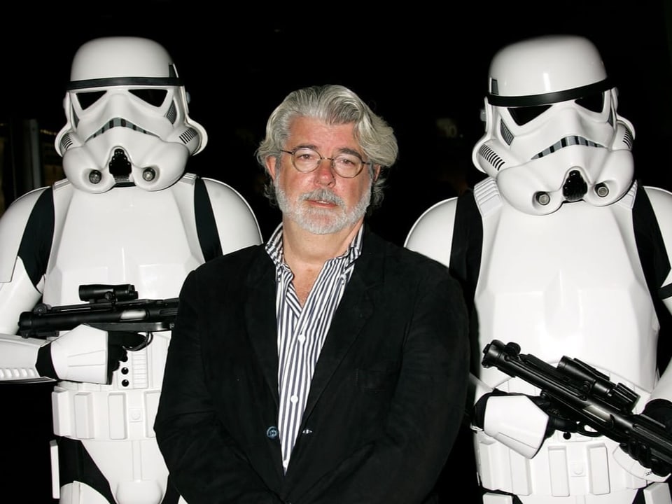 George Lucas steht zwischen den Soldaten Stormtroopers.