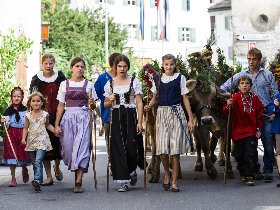 Kinder und Jugendliche in farbigen Trachten.